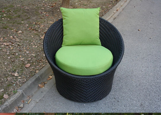 Chaises extérieures rondes noires de rotin, avec le coussin et l'oreiller verts